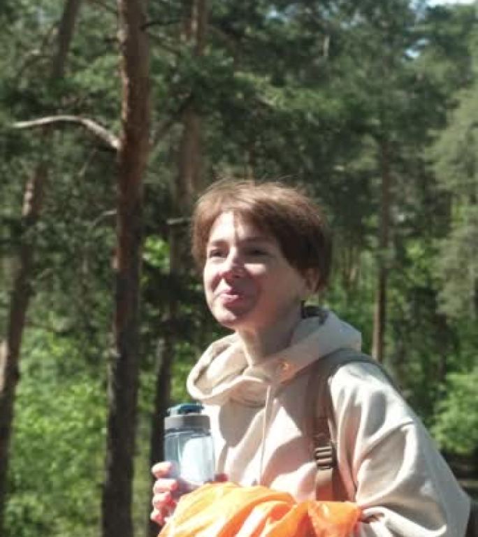 女人在森林中运动后正在喝水