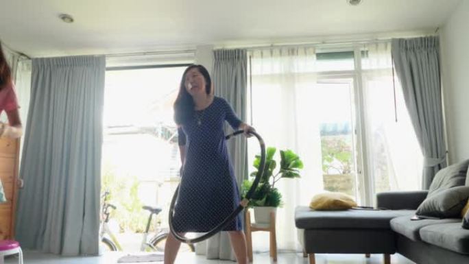 打喷嚏的亚洲妈妈在家里的窗户附近打呼啦圈，积极的生活方式理念。