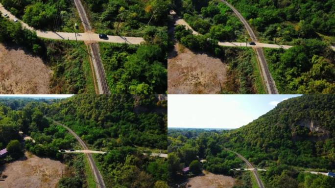 绿色森林中的铁路。汽车在穿越空旷的铁路的乡村道路上行驶