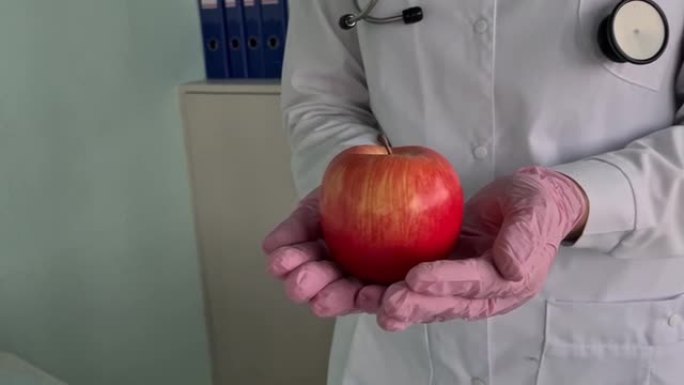 医学治疗师医生拿着红色新鲜成熟的苹果
