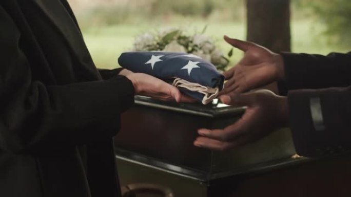 军事牧师向已故的退伍军人寡妇赠送美国葬礼旗帜