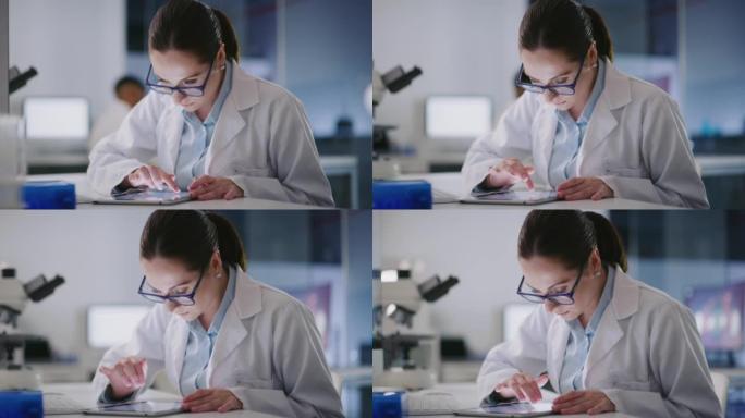 年轻的科学家在实验室里使用数字平板电脑。从事法医和医学研究的女性病理学家，同时在线分析数据和发现。研