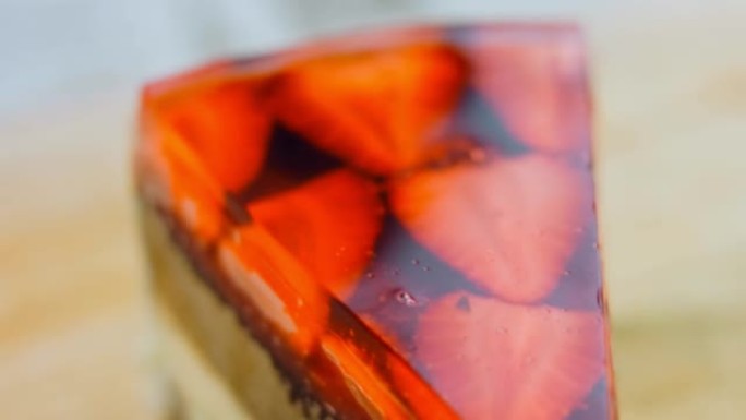 一片草莓和果冻蛋糕。微距和滑块拍摄。背景是复古的气氛