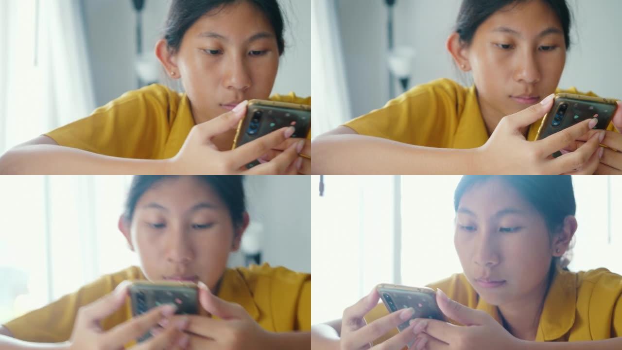 亚洲女孩在家使用靠近窗户的智能手机，生活方式概念。