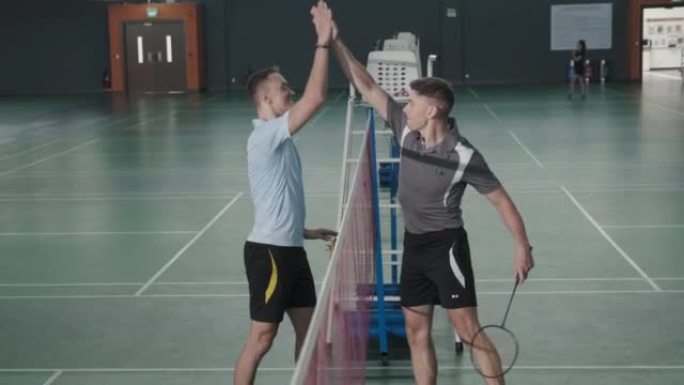 两名网球运动员在球场上聊天并击掌