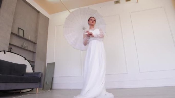 穿着白色婚纱的女孩摆姿势，拿着白色雨伞。
