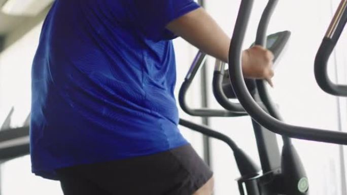 胖乎乎的男人在健身房的精英教练身上锻炼的特写镜头。