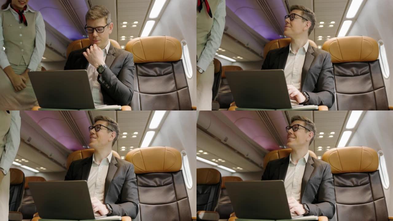 准备旅行时，使用笔记本电脑工作的商人坐在飞机上。商务舱飞机的服务。旅行安全