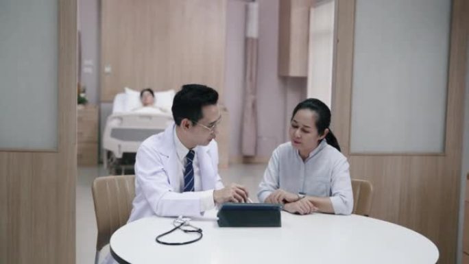 资深亚洲妇女听取医生对儿子病情的建议。