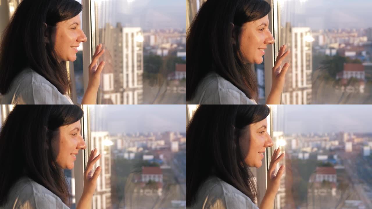 窗户上的幸福女人，手放在玻璃上，带着微笑看起来梦dream以求