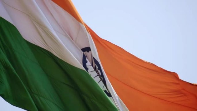 印度国旗在蓝天下高高飘扬，印度国旗飘扬，印度国旗在独立日和印度共和国日，倾斜拍摄，挥舞印度国旗，飘扬