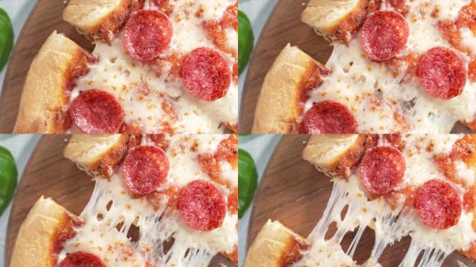 撕开一片意大利辣香肠披萨 -- 有弹性的马苏里拉奶酪的餐桌顶视图