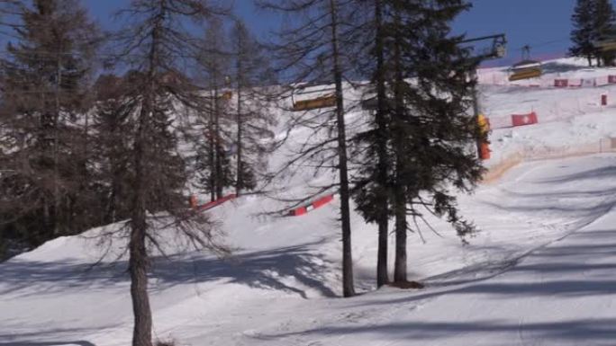 雪地公园，运动中的升降椅和从美丽的雪坡上下来的高山滑雪者的景色