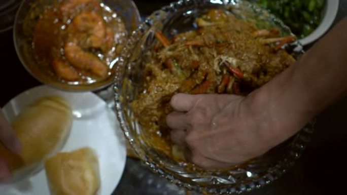 双手吃新加坡辣椒蟹配油炸面包蘸咖喱酱中式食品