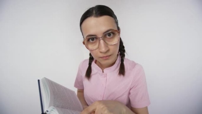 书呆子的学生女孩用手指指着教科书