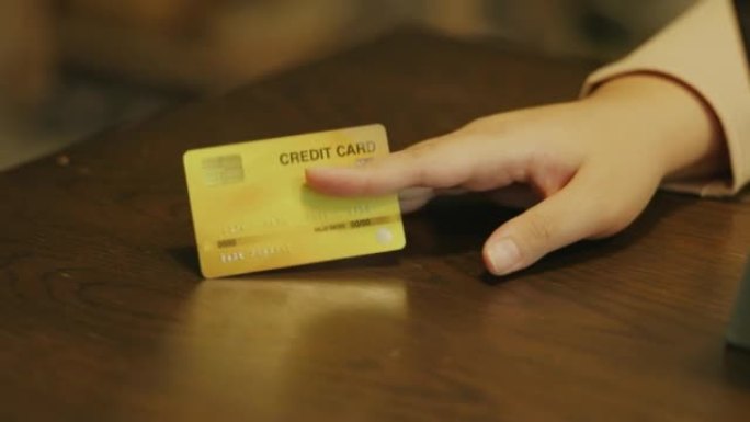 女人手里拿着信用卡，等着用网上购物付款。