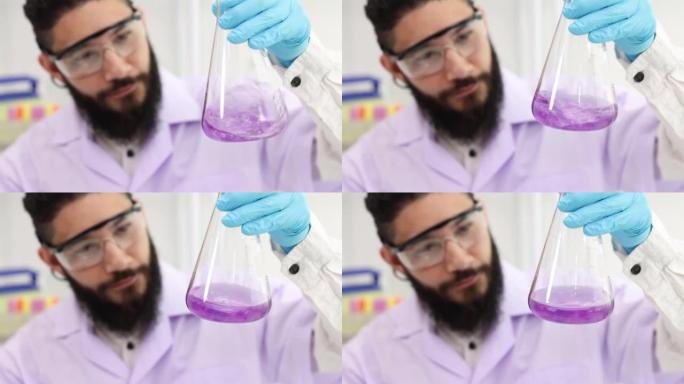 科学家将溶液放入实验室烧瓶中。使瓶子里的蓝色水变成紫色。摇动装有化学药品的瓶子。在实验室工作的科学家
