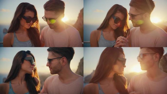 浪漫的夏天。夫妇在度假时戴着墨镜坐在长凳上，背景是金色的日落。爱的吻