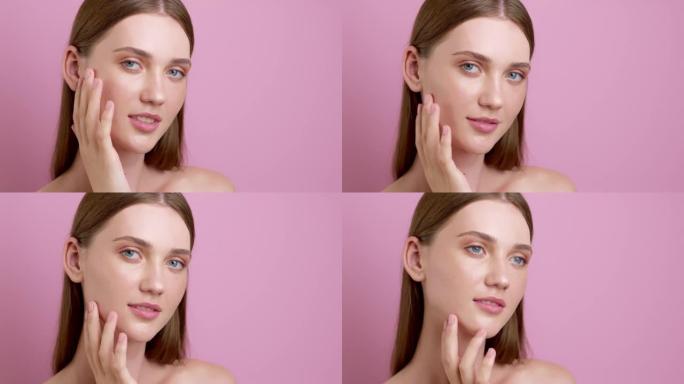 美丽的年轻女子模特用手指触摸她的脸在粉红色的背景。健康清洁护肤理念。