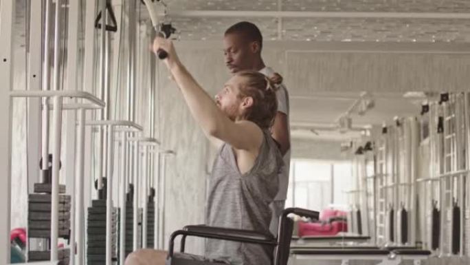 轮椅男子与物理治疗师一起在举重机上锻炼