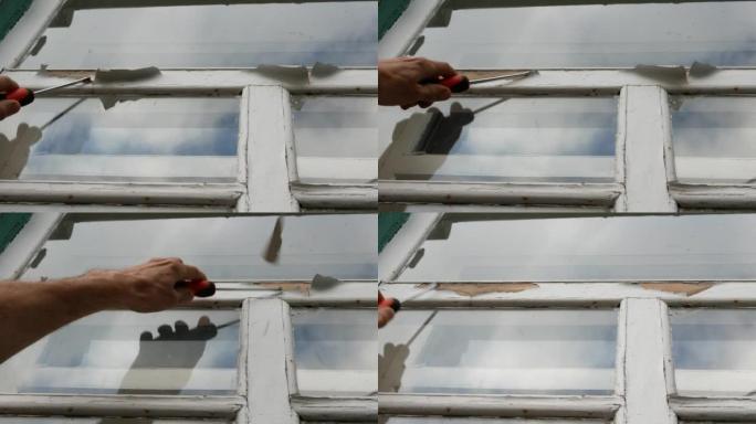 清除窗户木质表面的旧裂缝油漆。