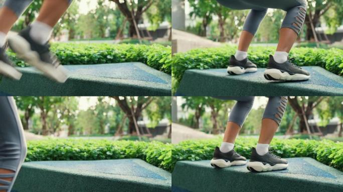 特写快乐年轻运动型亚洲女性从侧面角度穿着运动服在公园做体重跳跃深蹲在家庭花园公园开始晨练。