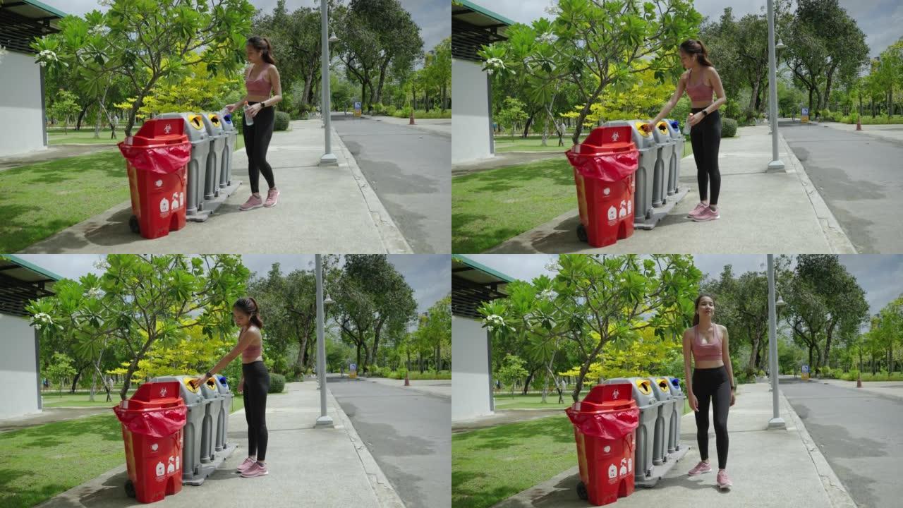 在公园锻炼的女人把水瓶扔进垃圾桶，生态概念，回收