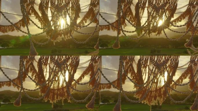 户外婚礼场地波西米亚蒂皮拱门装饰上的节日串灯照明。夏季乡村婚礼上，复古串灯灯泡花环闪耀在椅子上方。