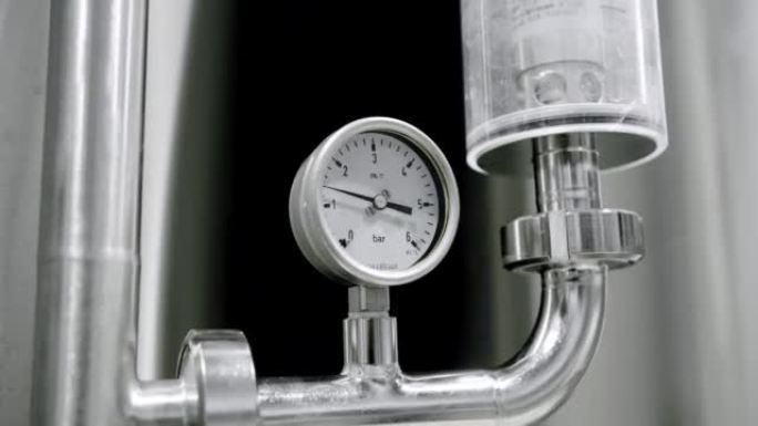 用于测量生产啤酒的储液罐中压力的检测器的详细视图。恒温器温度上升。工厂啤酒罐里的麦芽粒。沸腾谷物麦芽