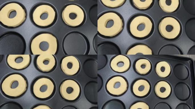 黑色托盘上的生甜甜圈准备烘烤顶视图平滑运动4k视频剪辑。