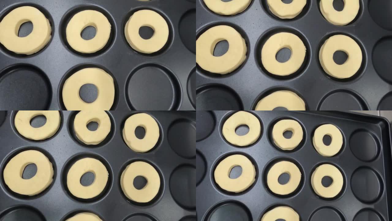 黑色托盘上的生甜甜圈准备烘烤顶视图平滑运动4k视频剪辑。