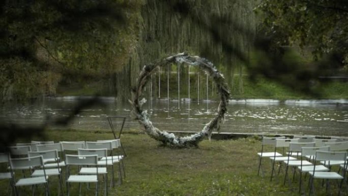 圆形婚礼拱门站在河边，公园里有水流