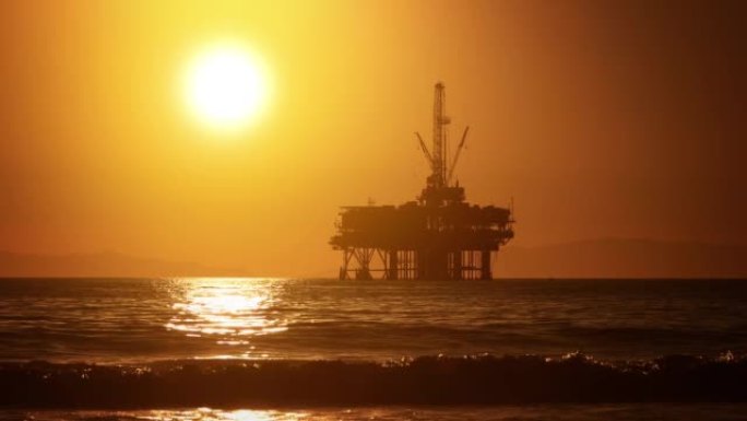 海上石油平台后面的太阳落山