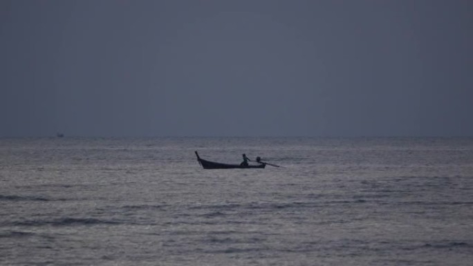 渔船上的渔夫在日落或日出时在海上捕鱼黑暗的天空背景