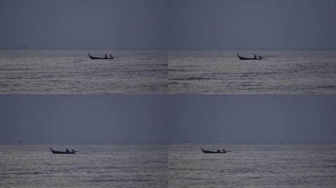渔船上的渔夫在日落或日出时在海上捕鱼黑暗的天空背景