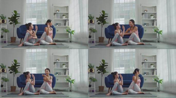 母亲正在教女儿如何做瑜伽姿势，坐姿脊柱扭转姿势或Ardha Matsyendrasana。