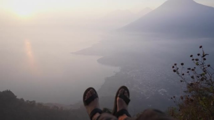 危地马拉阿蒂特兰湖背景下坐在山上的人的个人视角