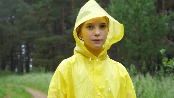 穿着黄色雨衣的严肃女孩在镜头前看起来很难过
