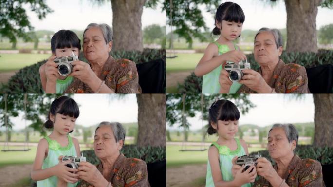 奶奶和孙女在公园玩耍，拍摄相机，玩秋千，母亲节，家庭日概念。