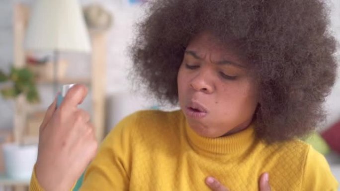 肖像美丽的非洲裔美国黑人发型突然哮喘发作是在公寓特写中使用喷雾