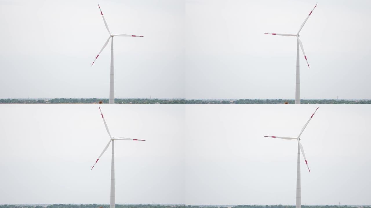 相机向后拉，以鸟瞰图显示一排长长的海上风力涡轮机在低太阳下的海面。绿色和可再生能源概念