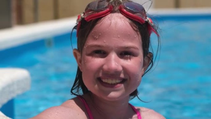 护目镜游泳池里的肖像微笑女孩。暑期旅游酒店假期或课程