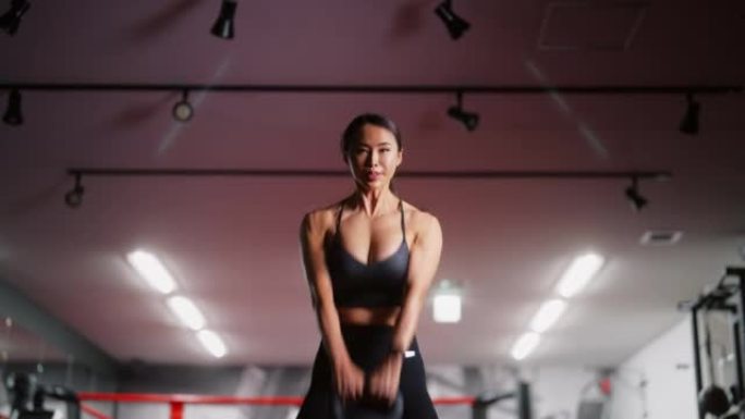 健身的女人在健身房使用举重和训练器材进行肌肉训练