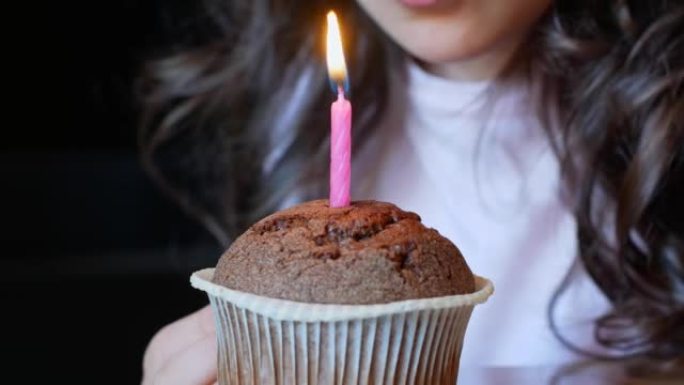 孩子在生日蛋糕上吹出燃烧的蜡烛。生日。