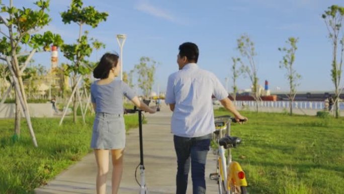 与朋友在公园散步，骑自行车和电动踏板车