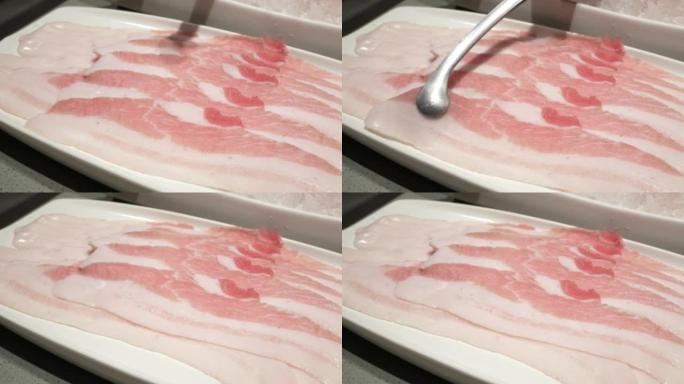 使用筷子采摘新鲜的生猪肉切片