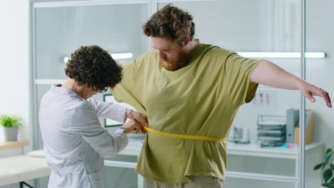 女医生测量超重患者的腰部