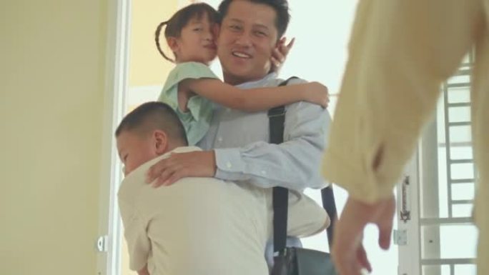 父亲下班回家，兴奋的孩子在家门口奔跑和拥抱心爱的父亲时，幸福的亚洲家庭的幸福时刻。