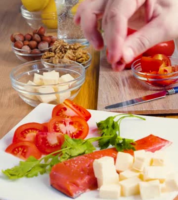 人的手在鱼和奶酪上撒上盐。酮饮食和健康饮食理念，用于减肥和控制脂肪。