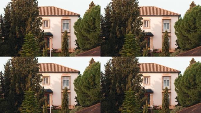 附近有松树生长的两层房屋的外部视图